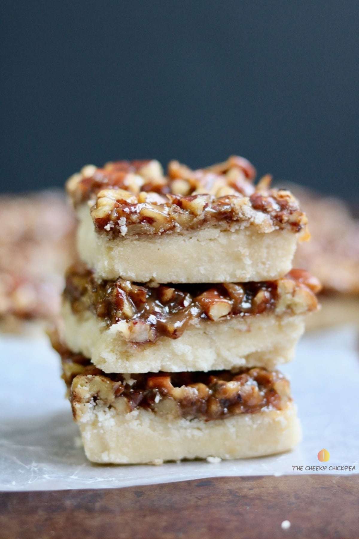 salted caramel & pecan vegan shortbread bars stacked on a counter