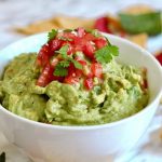 best guacamole recipe in a white bowl on marble countertop