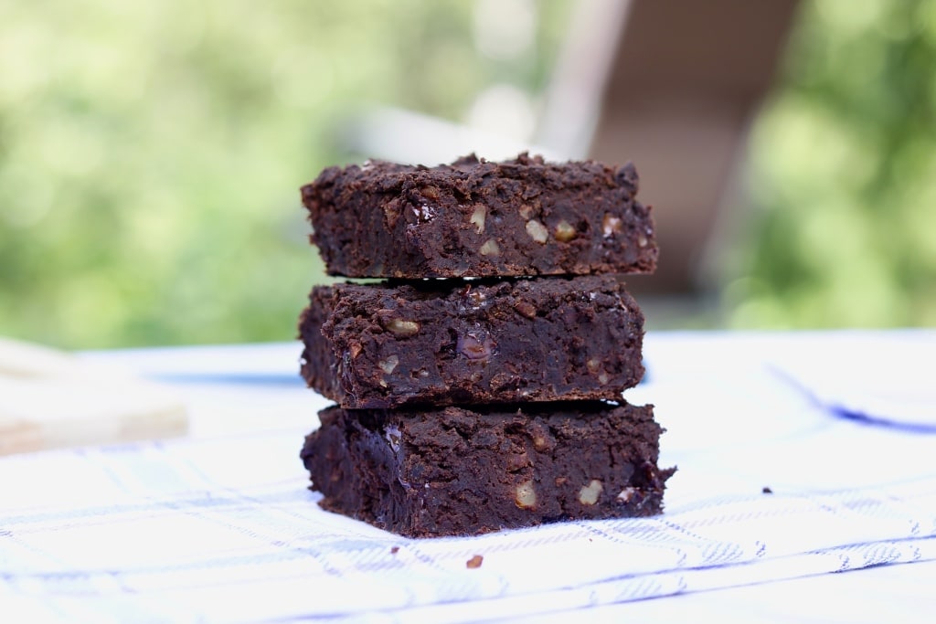  vegan black bean brownies on a white and blue cloth