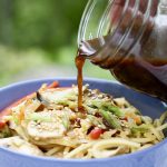 5 spice Stir-Fry sauce and noodles in blue bowl on marble countertop