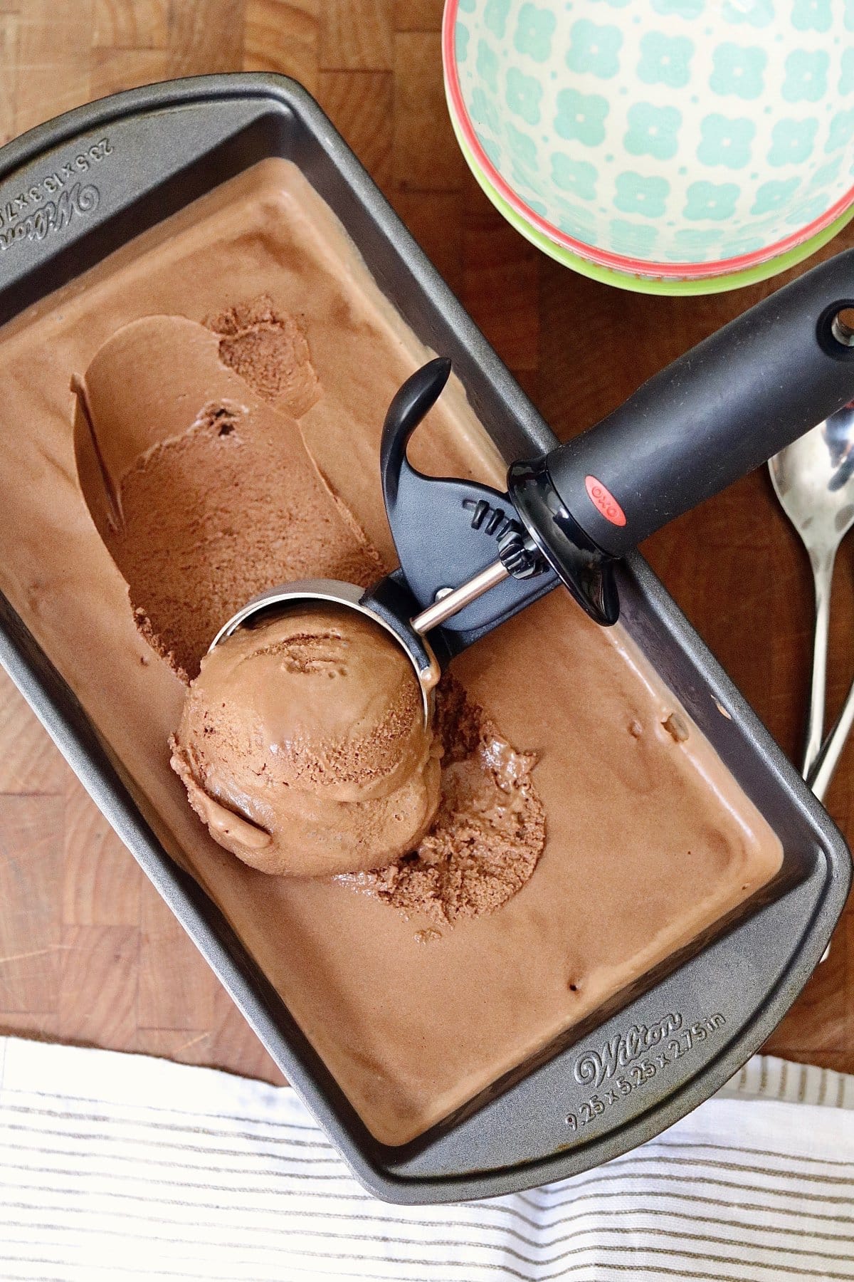 vegan chocolate ice cream being scooped from a container 