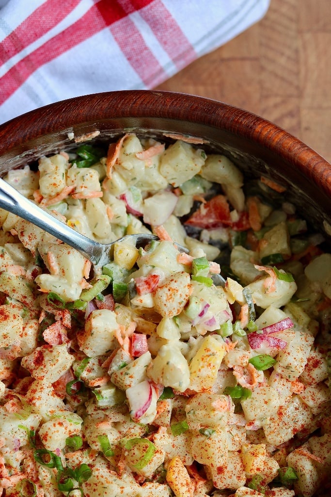 close up of vegan potato salad mixed in a salad bowl