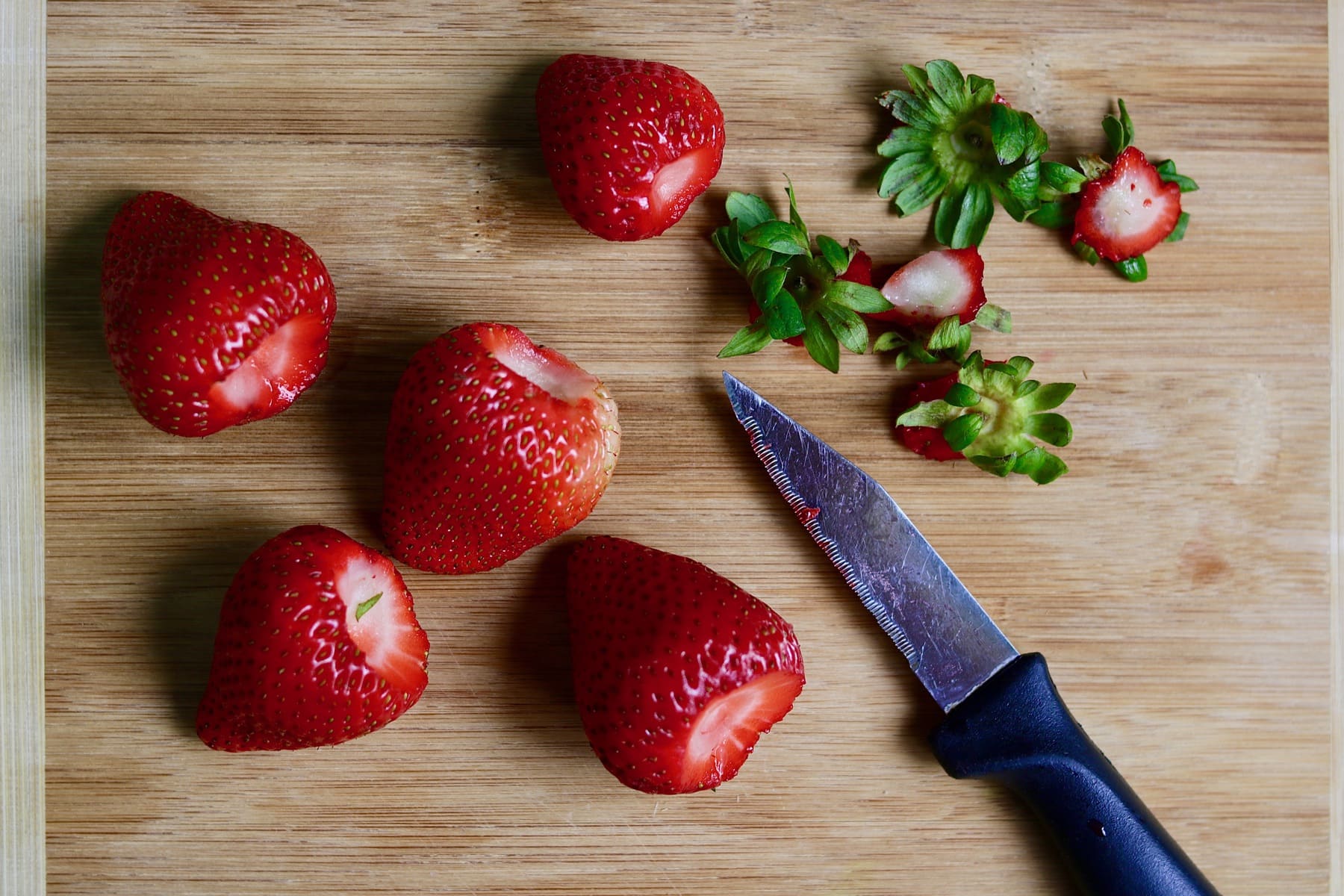 simple macerated strawberries on wooden cutting board