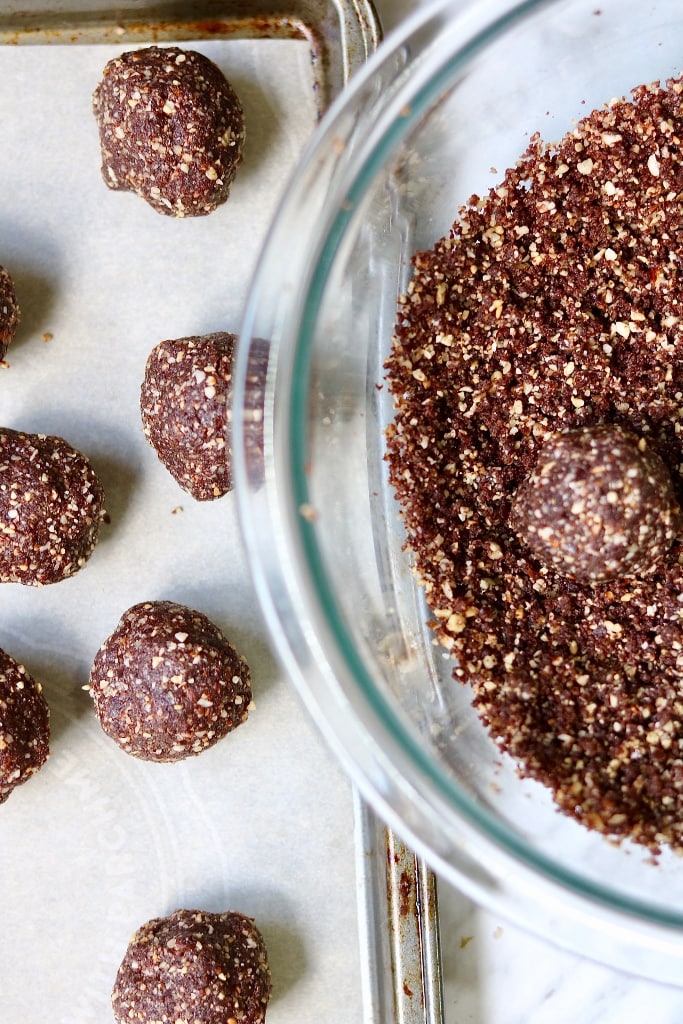nutty vegan chocolate truffles in a bowl and on parchment paper