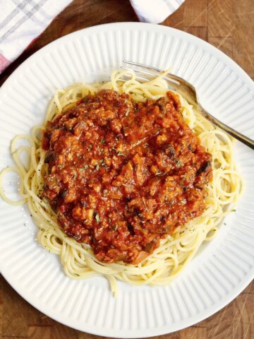vegan bolognese sauce on a plate atop spaghetti