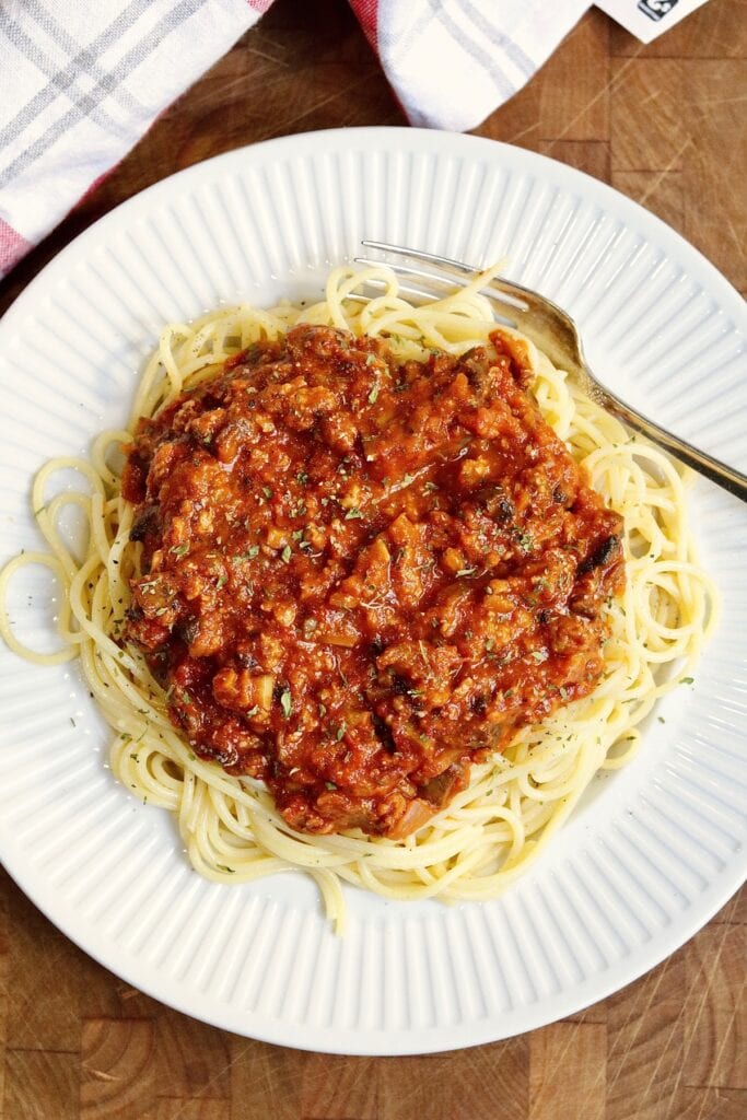 vegan bolognese sauce on a plate atop spaghetti