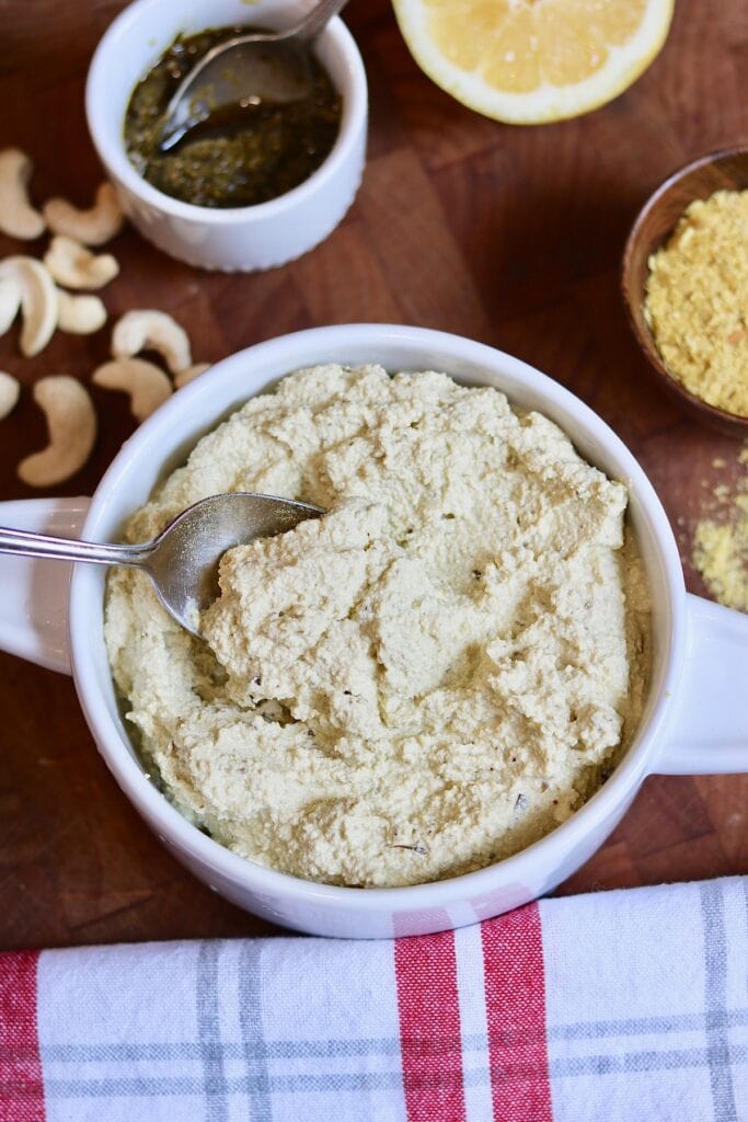 vegan ricotta cheese in a bowl surrounded by a few of the ingredients