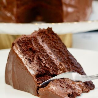 a slice of vegan chocolate cake on a plate with a fork