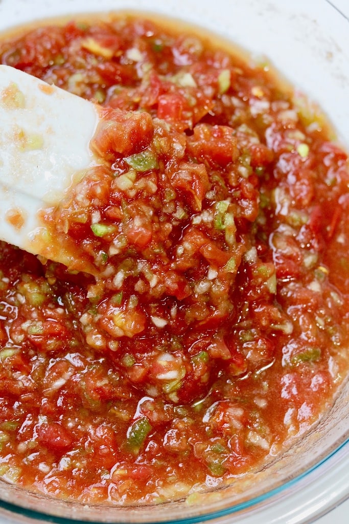 restaurant style salsa in a glass bowl with a white spatula 