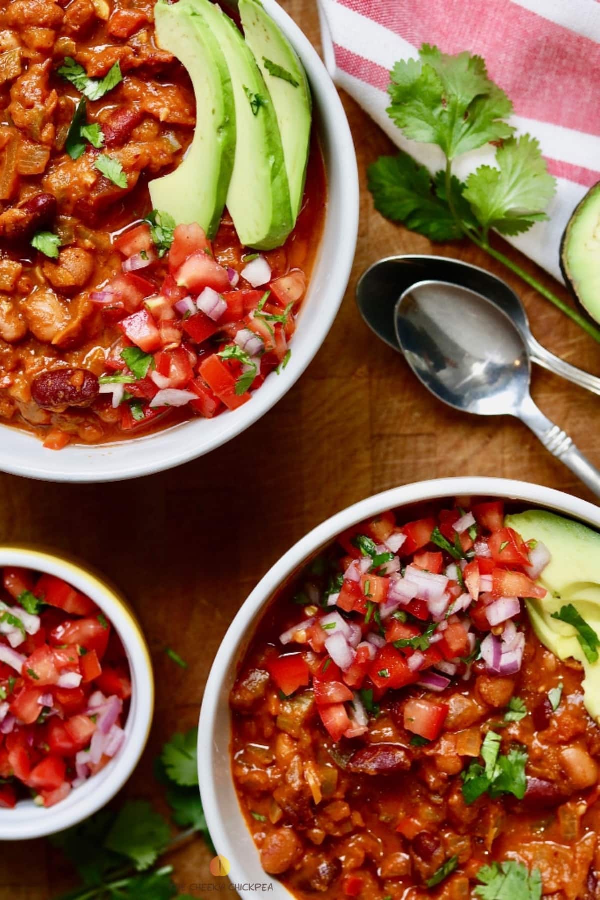 two bowls of vegan Chili with salsa and avocado on top
