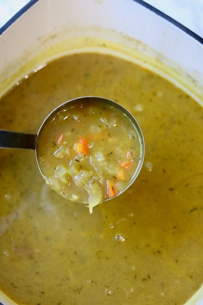 mulligatawny soup in a ladle over a soup pot 