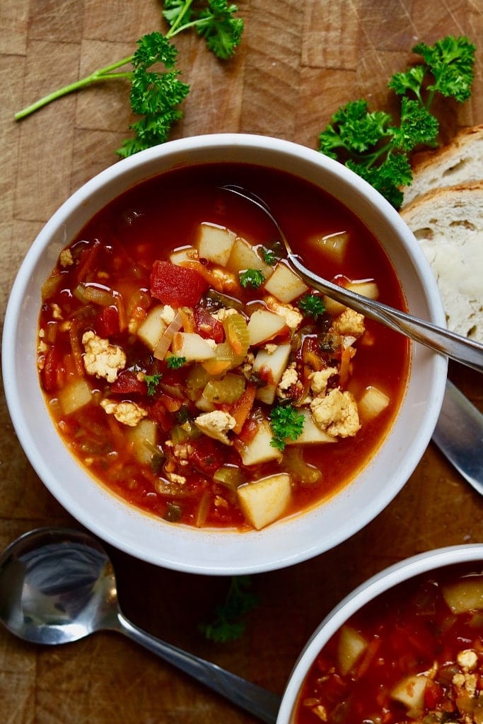 vegan hamburger soup in a white bowl on a wooden table