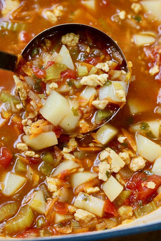 vegan hamburger soup in a pot with a ladle 