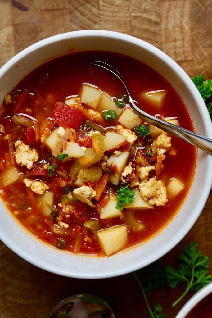 vegan hamburger soup in a white bowl on a wooden table