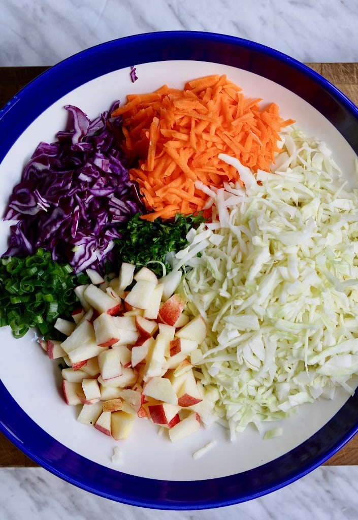 chopped vegetables in a large white bowl for classic vegan coleslaw