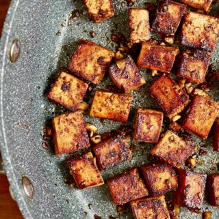 marinated tofu cubes frying in a pan