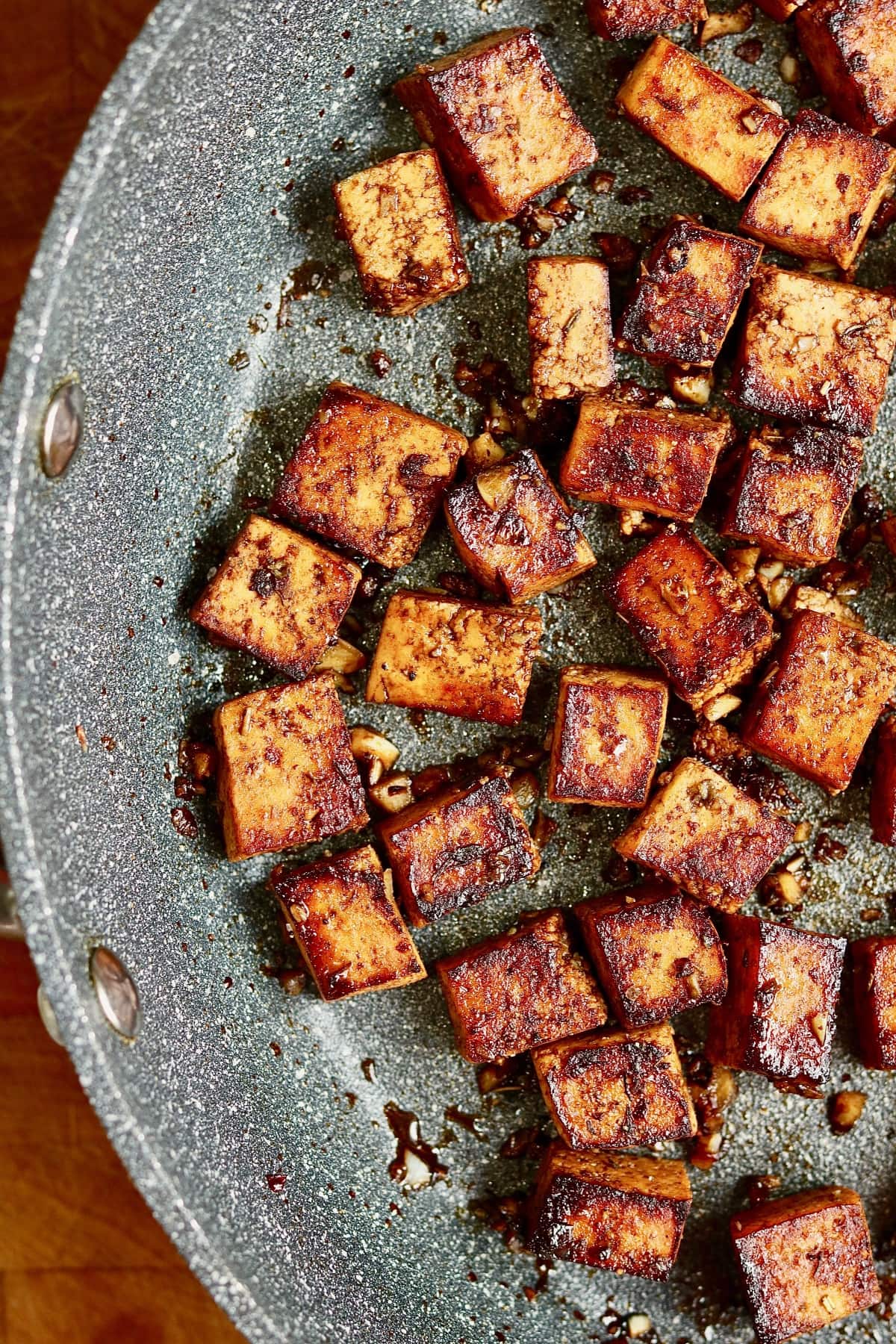 marinated tofu cubes frying in a pan