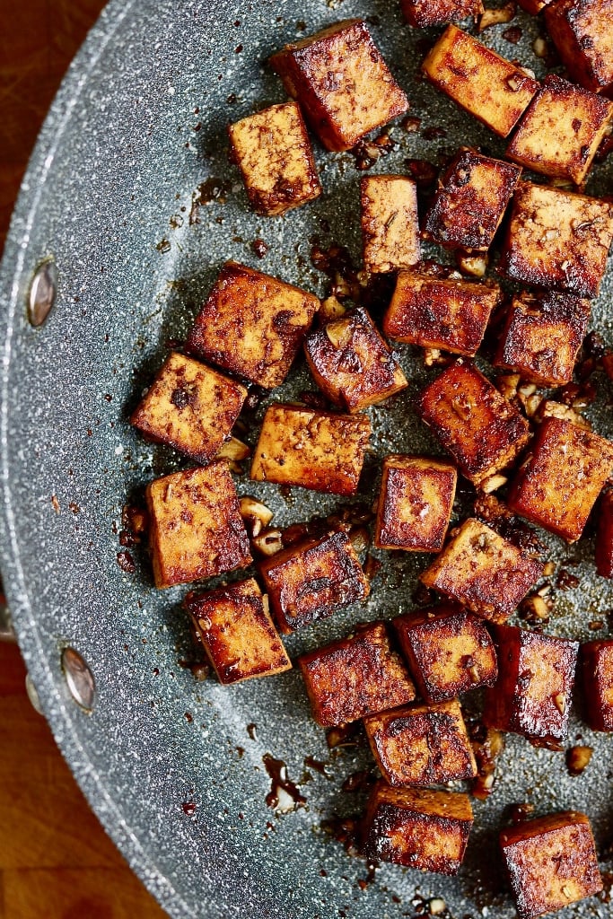 marinated tofu pieces in a skillet