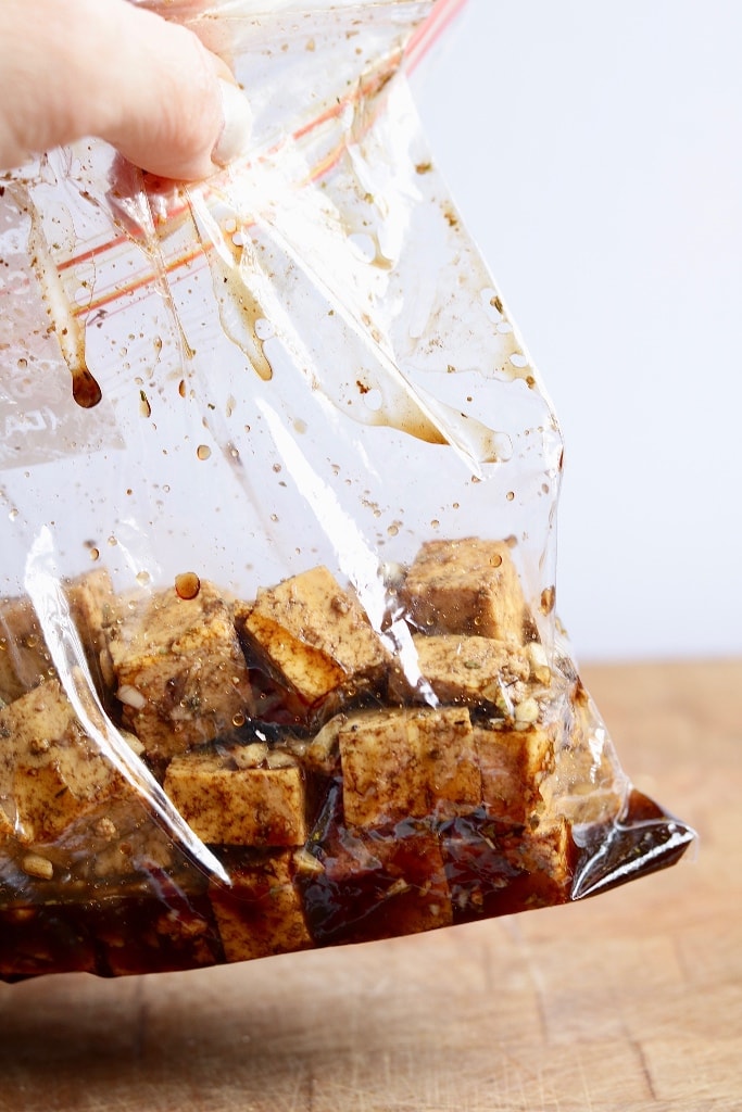 cubes of tofu marinating in ziplock bag with balsamic marinade ingredients 
