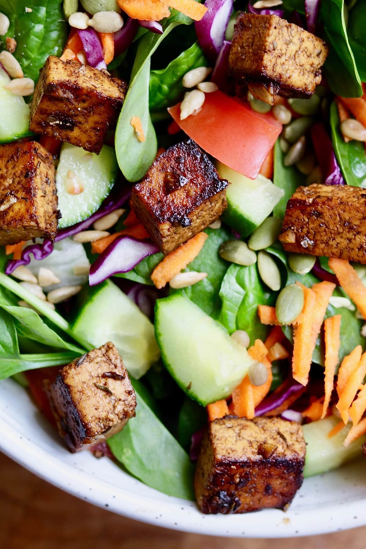 cubes of marinated tofu tossed in a green salad 