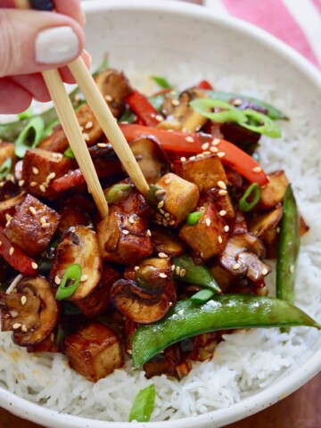 tofu stir fry in a white bowl with rice