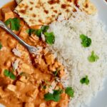 vegan butter chicken on a plate with rice and naan