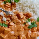 vegan butter chicken on a white plate with rice and a fork