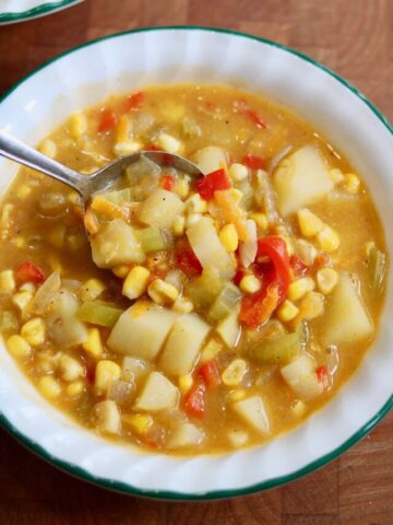 vegan corn chowder in a bowl with a spoon ready to serve