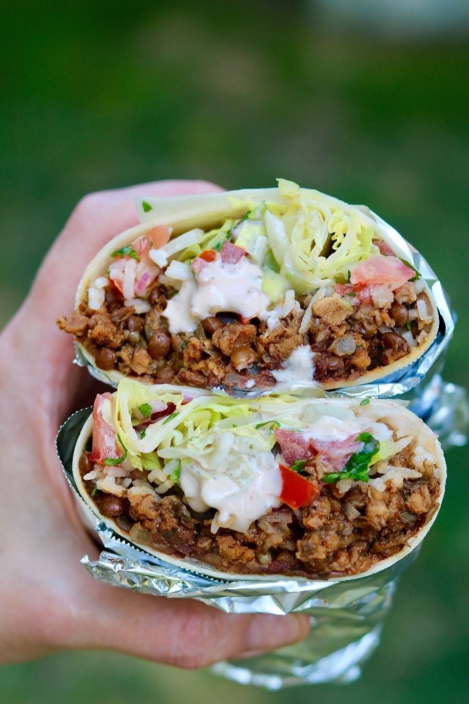 ultimate vegan burrito being held in the air