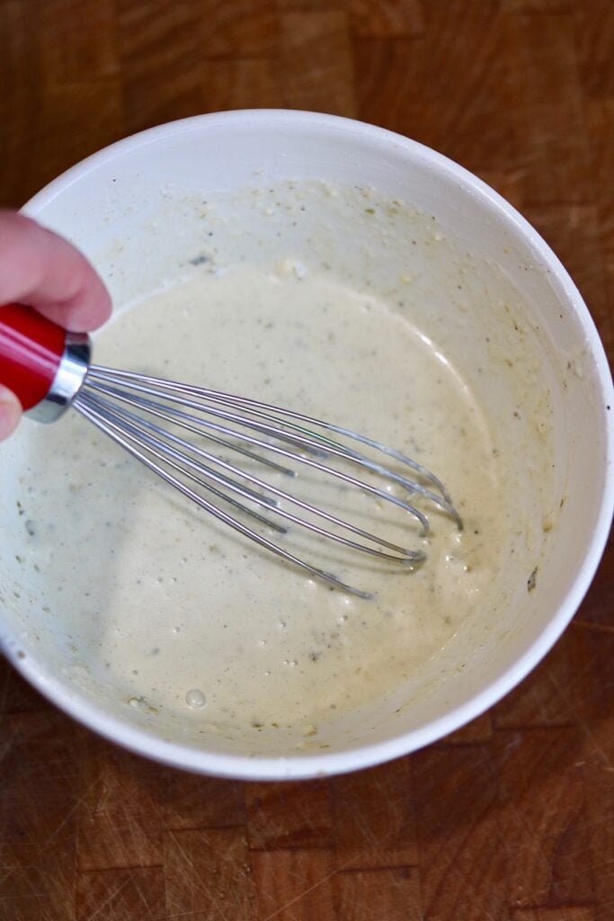 vegan Caesar dressing ingredients being whisked together in a bowl