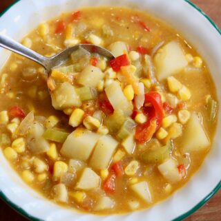 vegan corn chowder in a bowl with a spoon ready to serve