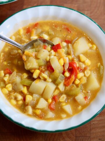 vegan corn chowder in a bowl with a spoon ready to serve