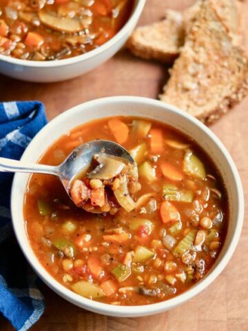 a bowl of italian lentil soup with a spoon