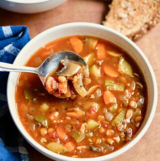 a bowl of italian lentil soup with a spoon