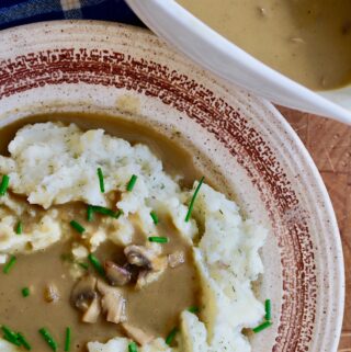 vegan mushroom gravy poured over a plate of mashed potatoes
