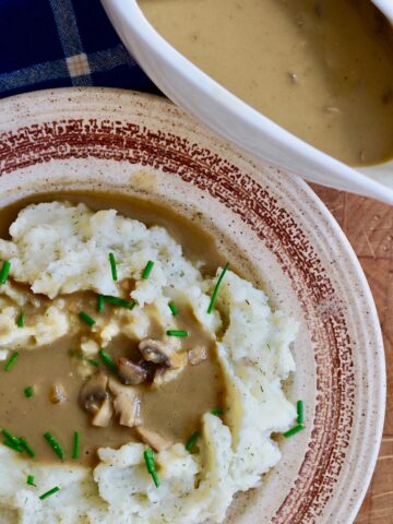 vegan mushroom gravy poured over a plate of mashed potatoes