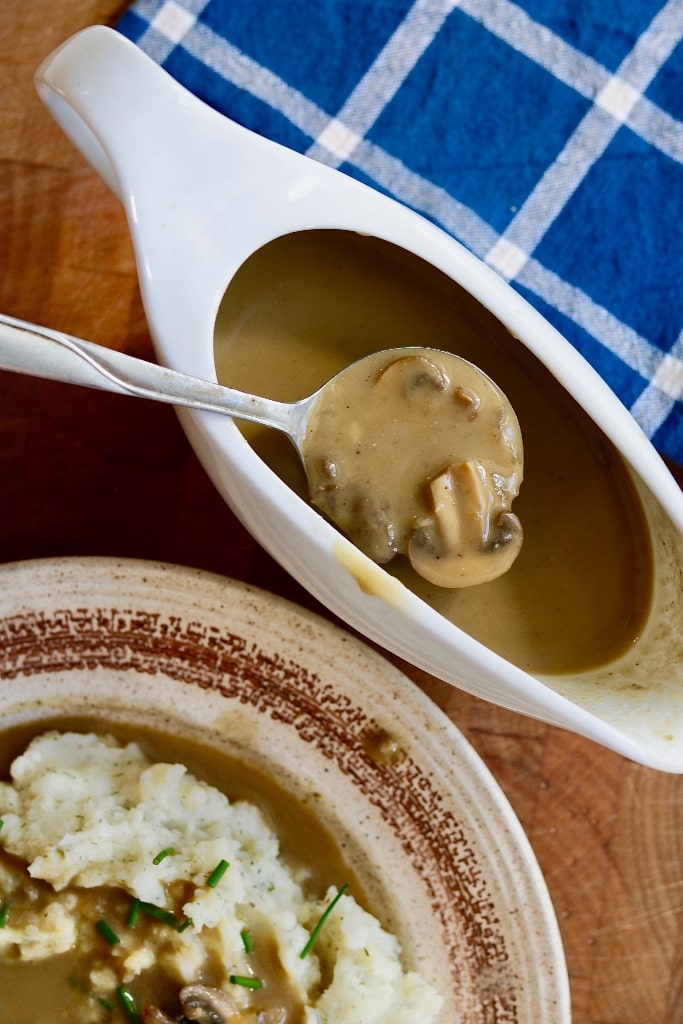 mushroom gravy in a gravy boat with a spoon