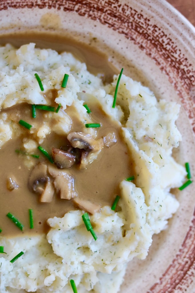 vegan mushroom gravy on top of a plate of mashed potatoes