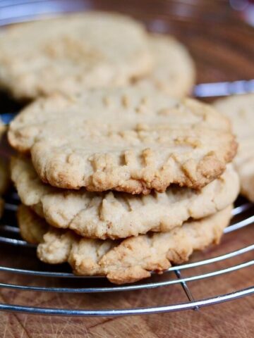 three vegan peanut butter cookies on a cooling rack