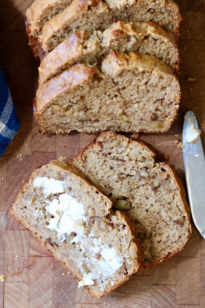 two slices of vegan banana bread on wooden cutting board