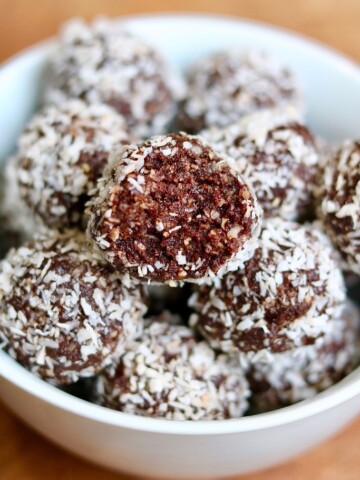 chocolate coconut date balls in a white bowl