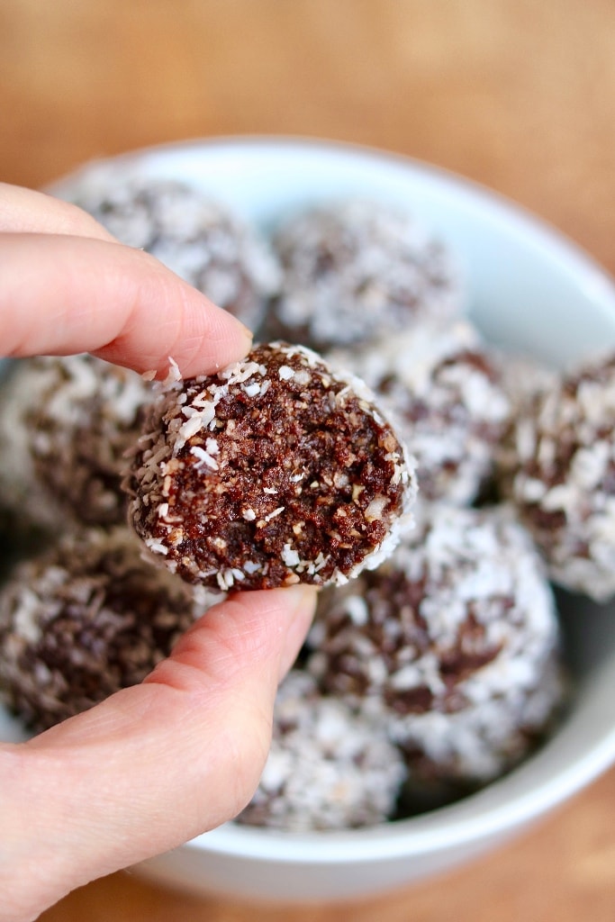 chocolate coconut date ball with a bite missing 