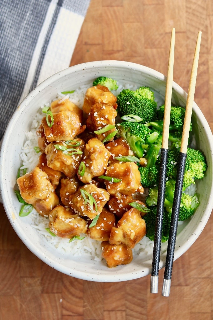 vegan orange chicken in a bowl with broccoli and rice