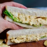 half a vegan egg salad sandwich being held