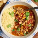 moroccan stew in a white bowl with couscous