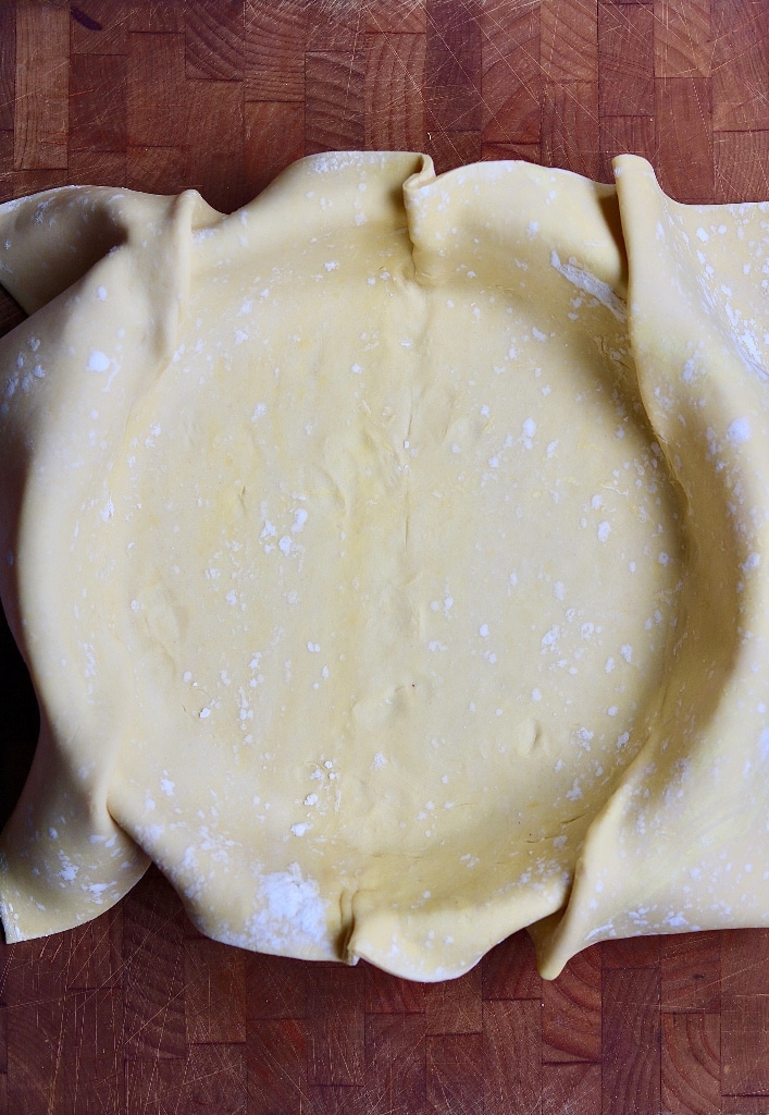 puff pastry sheet draped over a pie plate