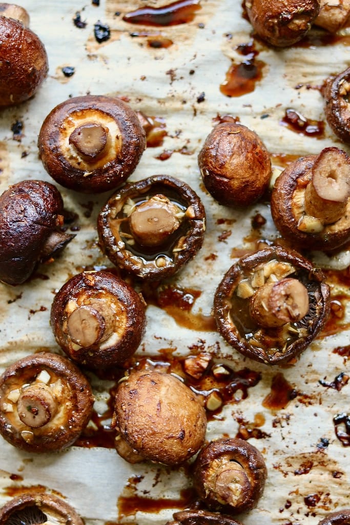 garlic balsamic roasted mushrooms on a parchment lined baking sheet