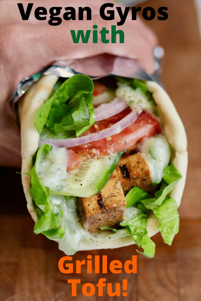 vegan gyro wrapped in foil being held