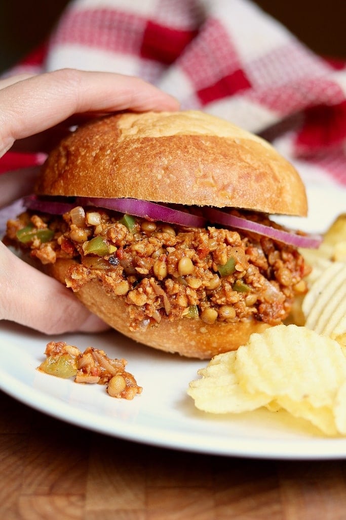 vegan sloppy Joe on a white plate being picked up