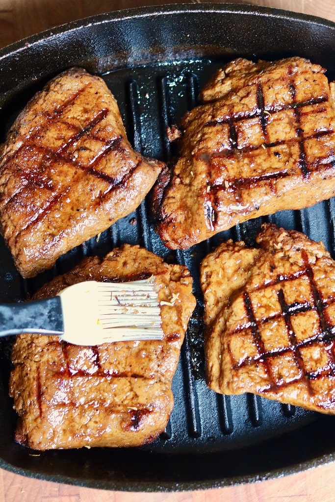 four vegan steaks being grilled 